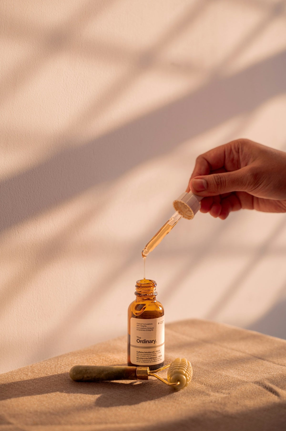 A serum dropper over an amber glass bottle in warm light